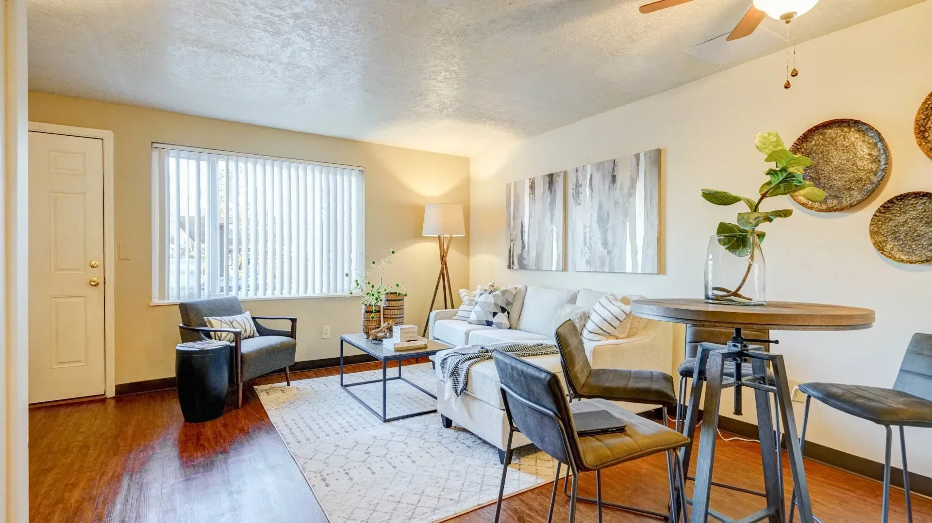 Cozy living room with a white couch, wooden table, and natural light.