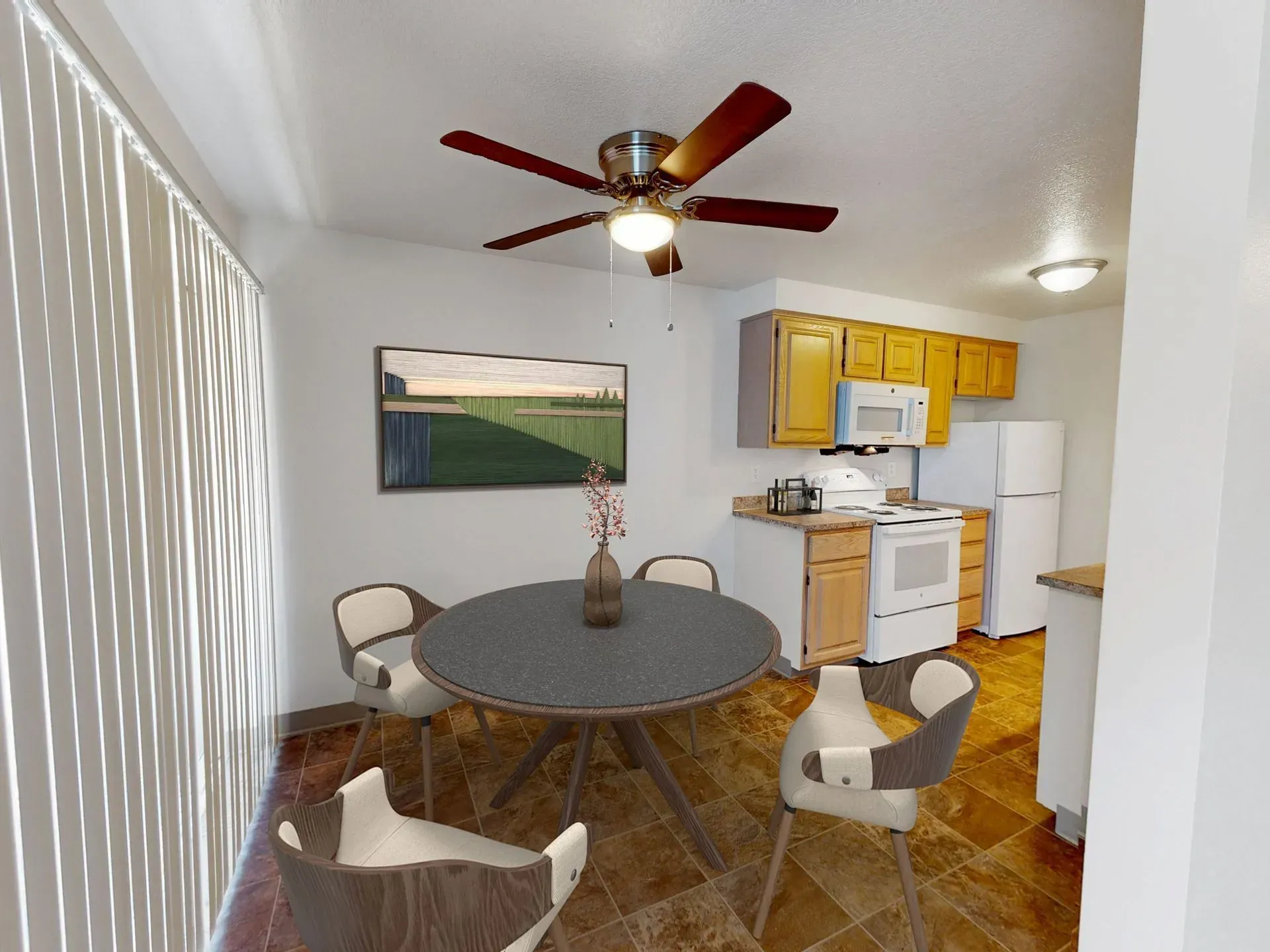 Kitchen/dining area with table, chairs, art, cabinets, appliances, and ceiling fan.