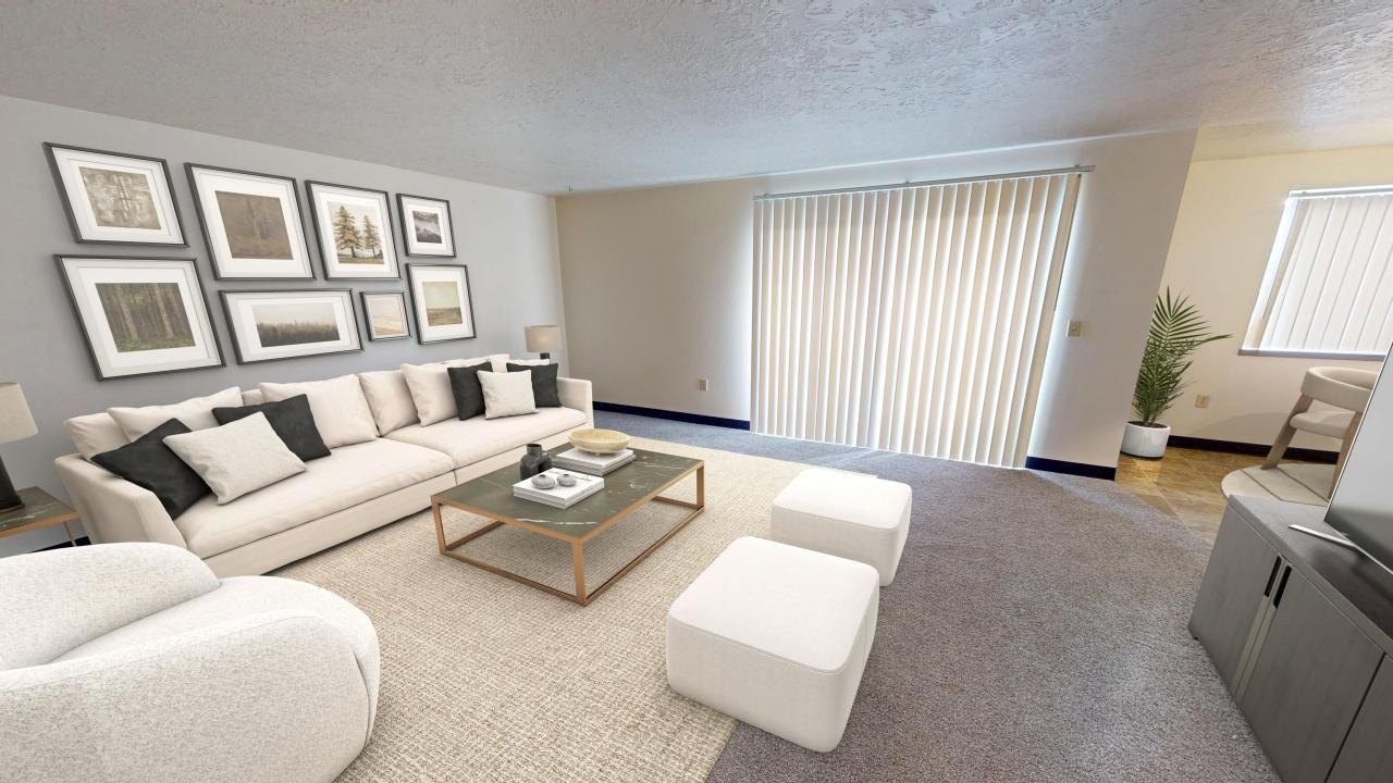 Living room with a large sofa, gallery wall, coffee table, and sliding glass door.