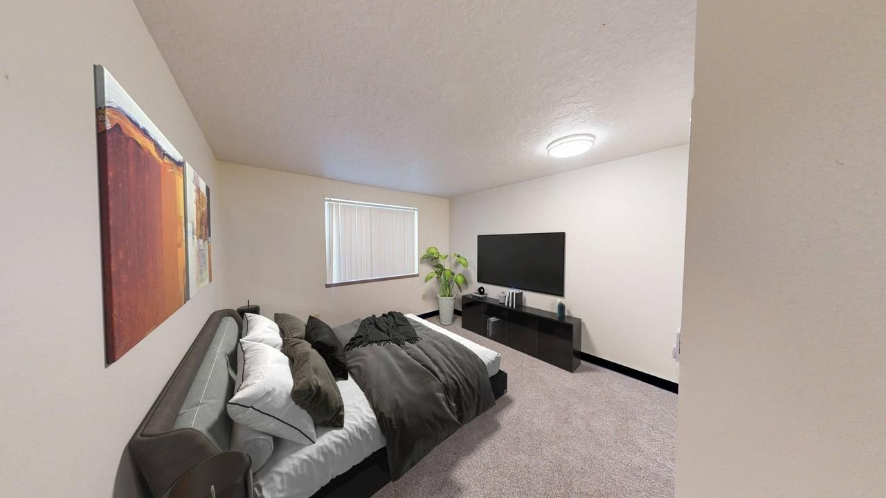 Living room with a sofa, TV, and artwork on the walls.