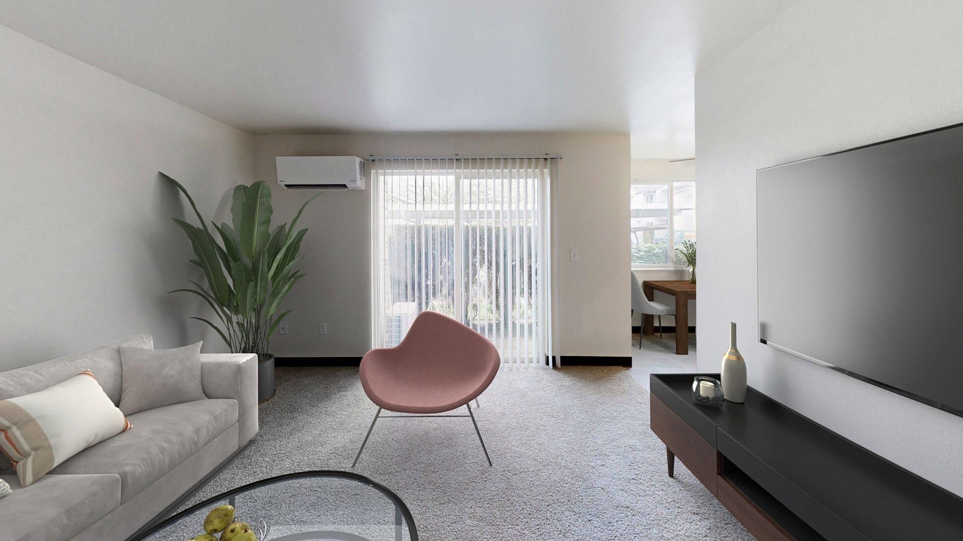 Living room with gray sofa, pink chair, TV, and large plant. Sliding glass door leads to a patio.