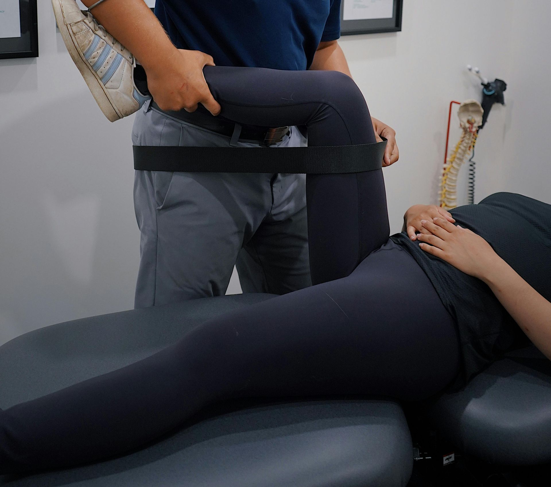 A Man Is Stretching a Woman 's Leg on A Table — Burwood Back Pain in Strathfield, NSW