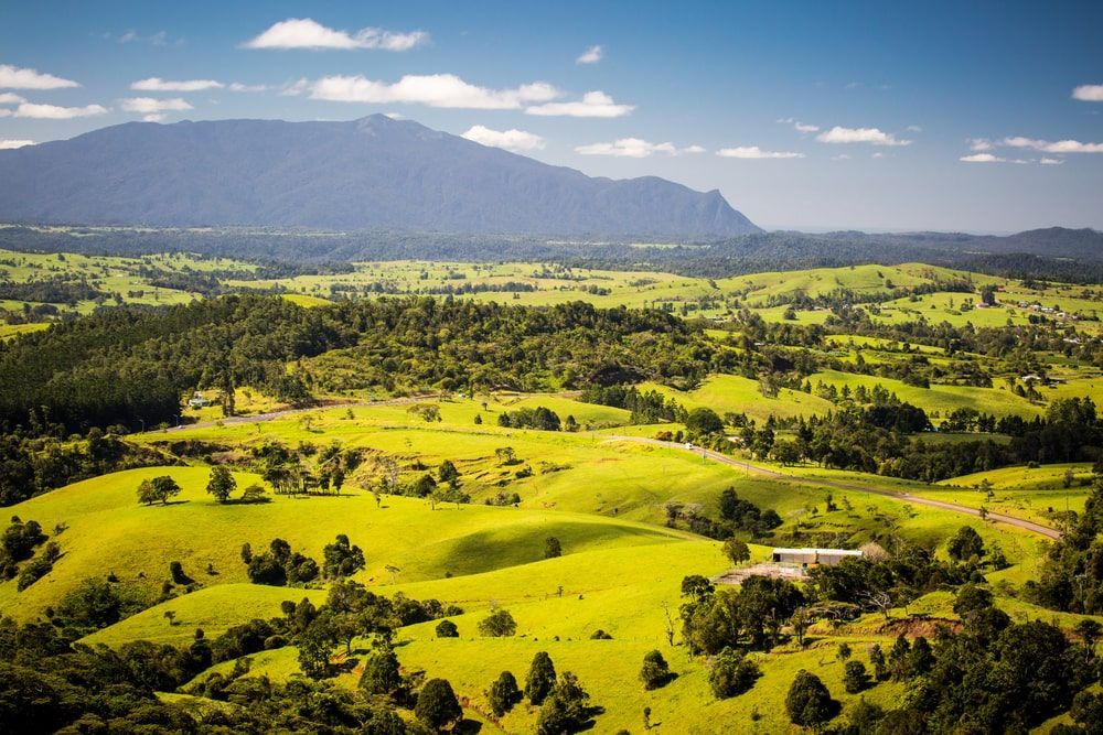 An Aerial View Of A Lush Green Valley With A Mountain In The Background — FNQ Freight & Logistics In Atherton Tablelands, QLD