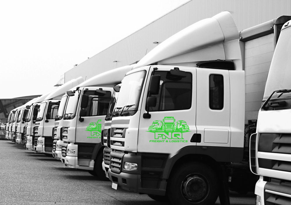 Line of white semi-trucks parked in a row outside a building; company logo visible on the door.— FNQ Freight & Logistics In Portsmith, QLD