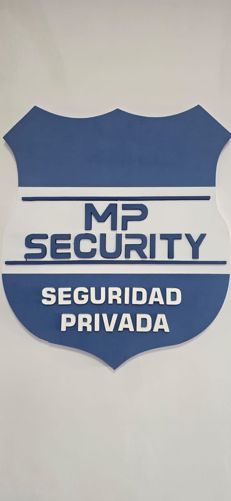 Logotipo en forma de escudo con “MP SECURITY” y “SEGURIDAD PRIVADA” en blanco sobre fondo azul y blanco.