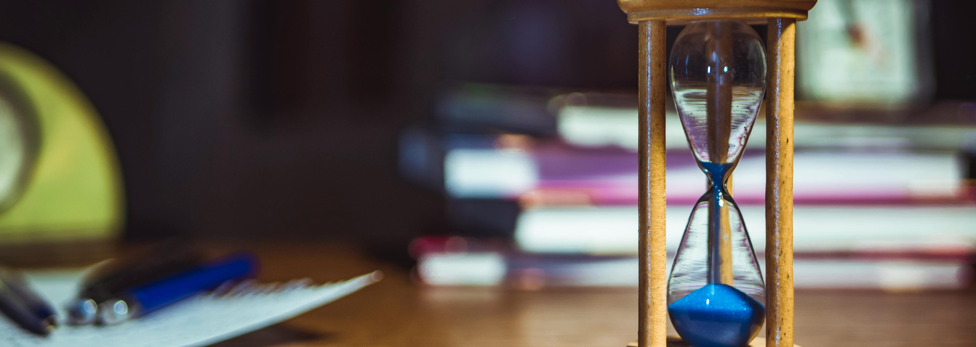 Picture of a hour glass next to books. 