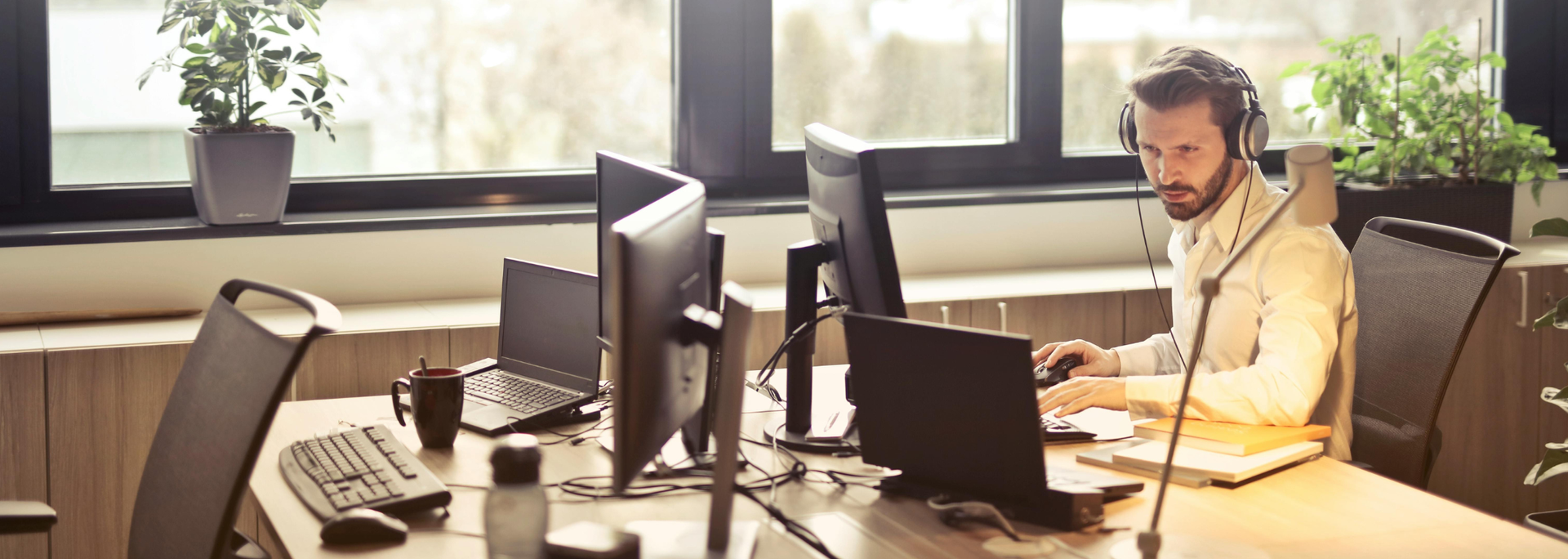 Picture of a man with headphones at a computer. 