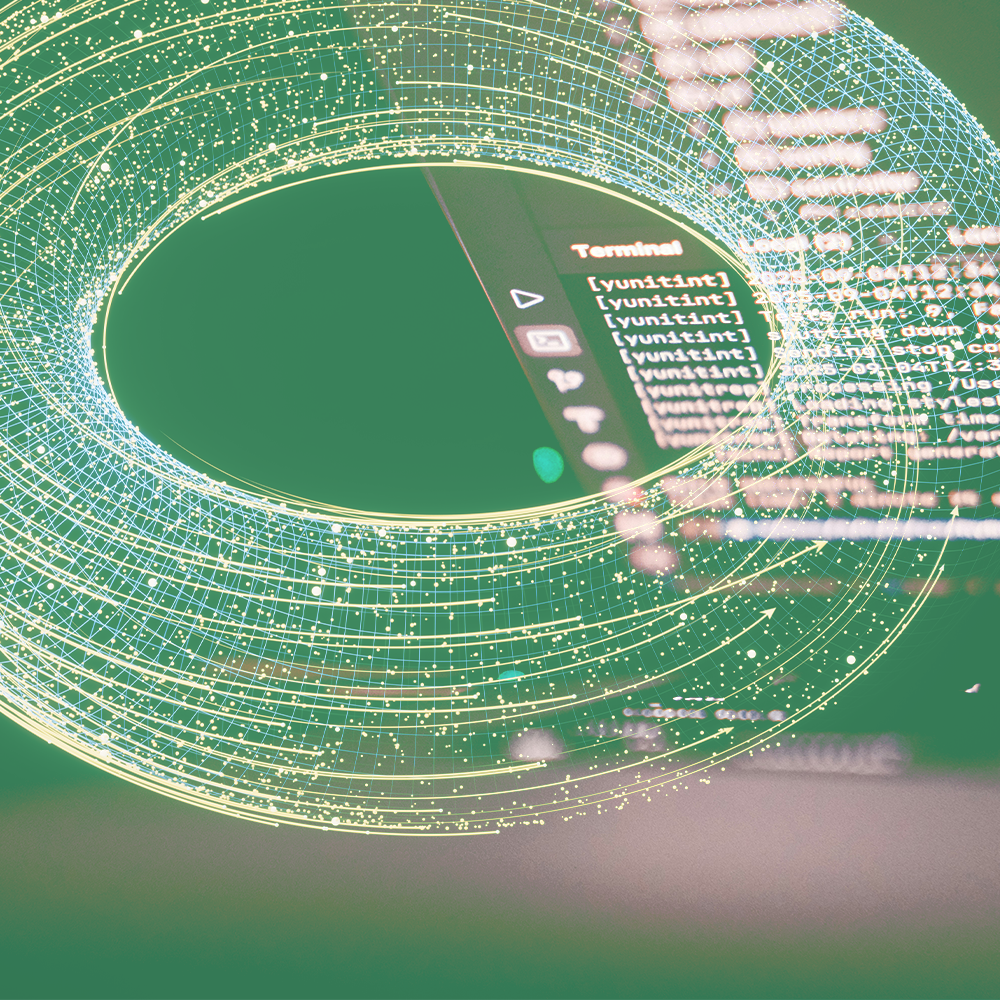 Green-toned image: a glowing, wireframe torus overlaid on a computer screen displaying code.