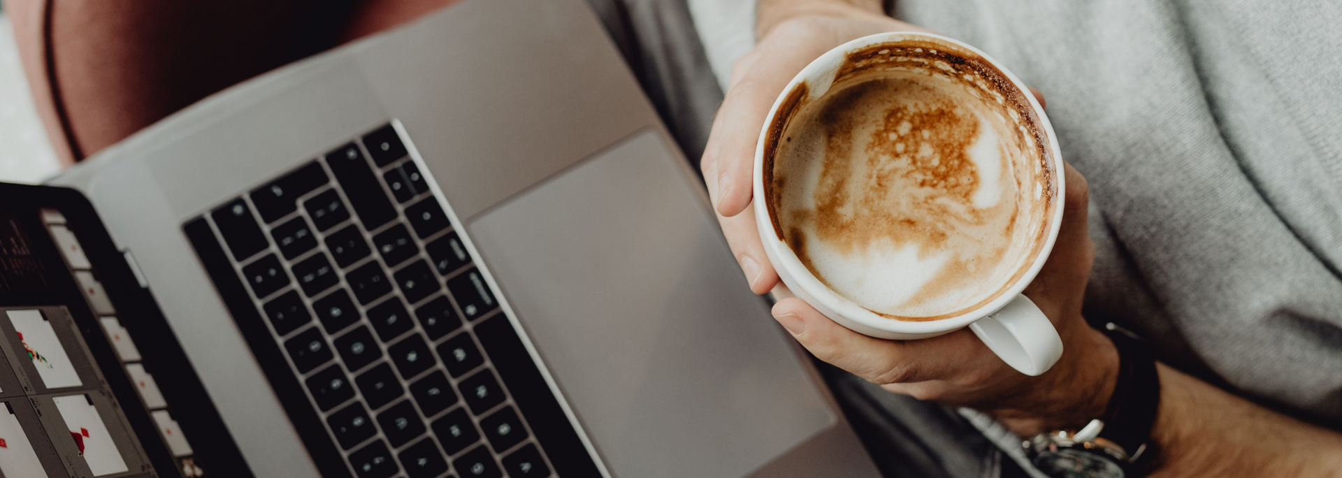 Picture of someone holding a coffee cup while working. 
