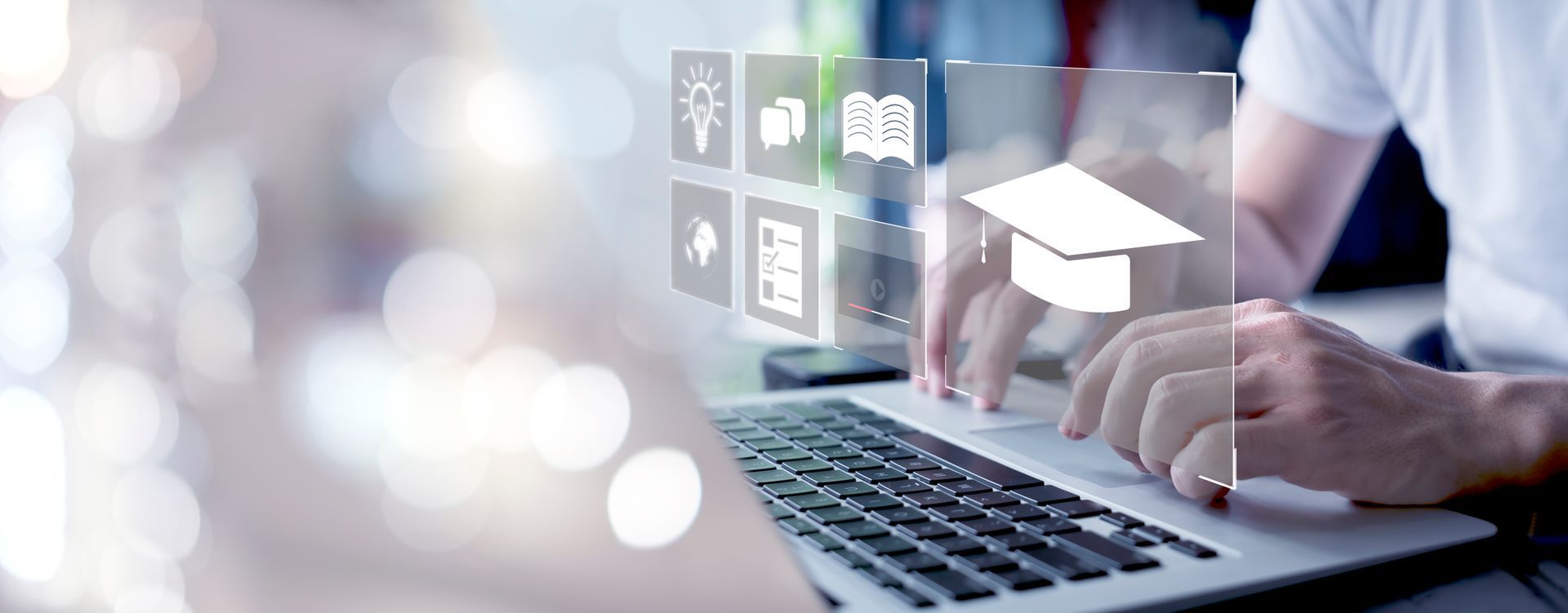 Person using a laptop with educational icons overlaid. Blurred background.