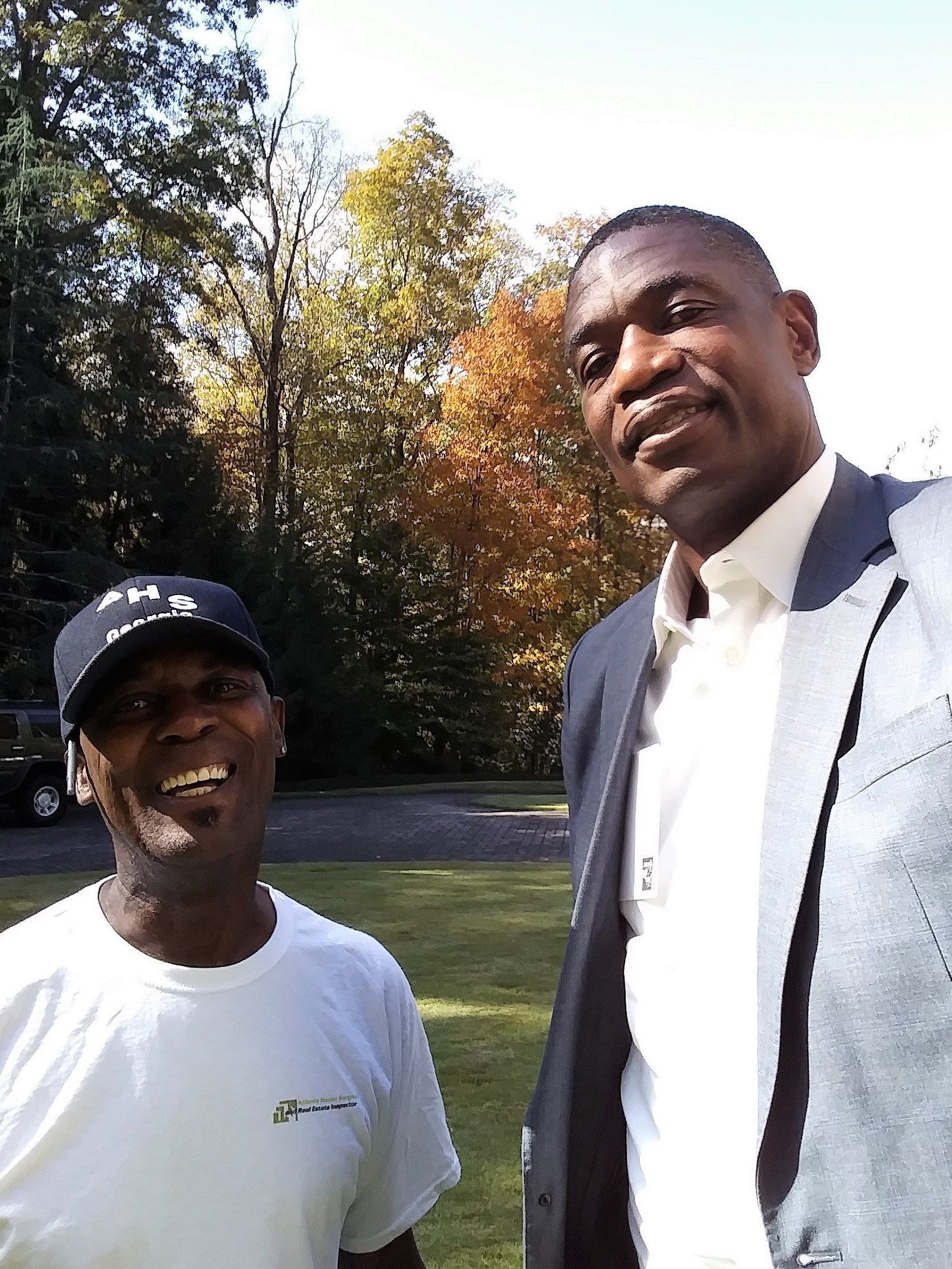 Two men are posing for a picture in a park