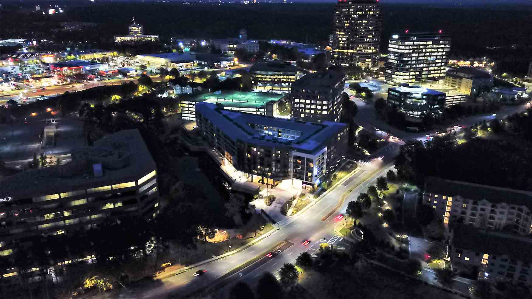 An aerial view of a city at night with lots of buildings