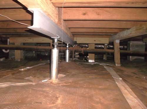 A crawl space with a lot of wooden beams and pipes.