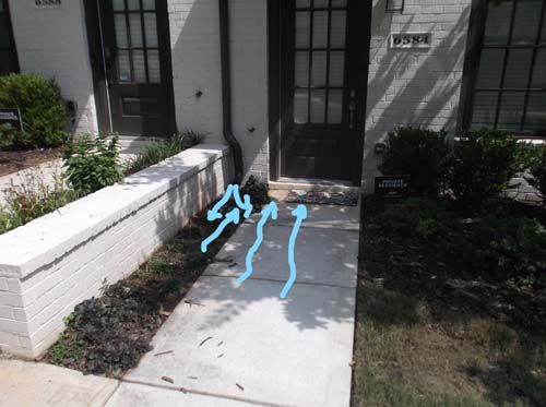 A white house with a blue arrow pointing to the front door