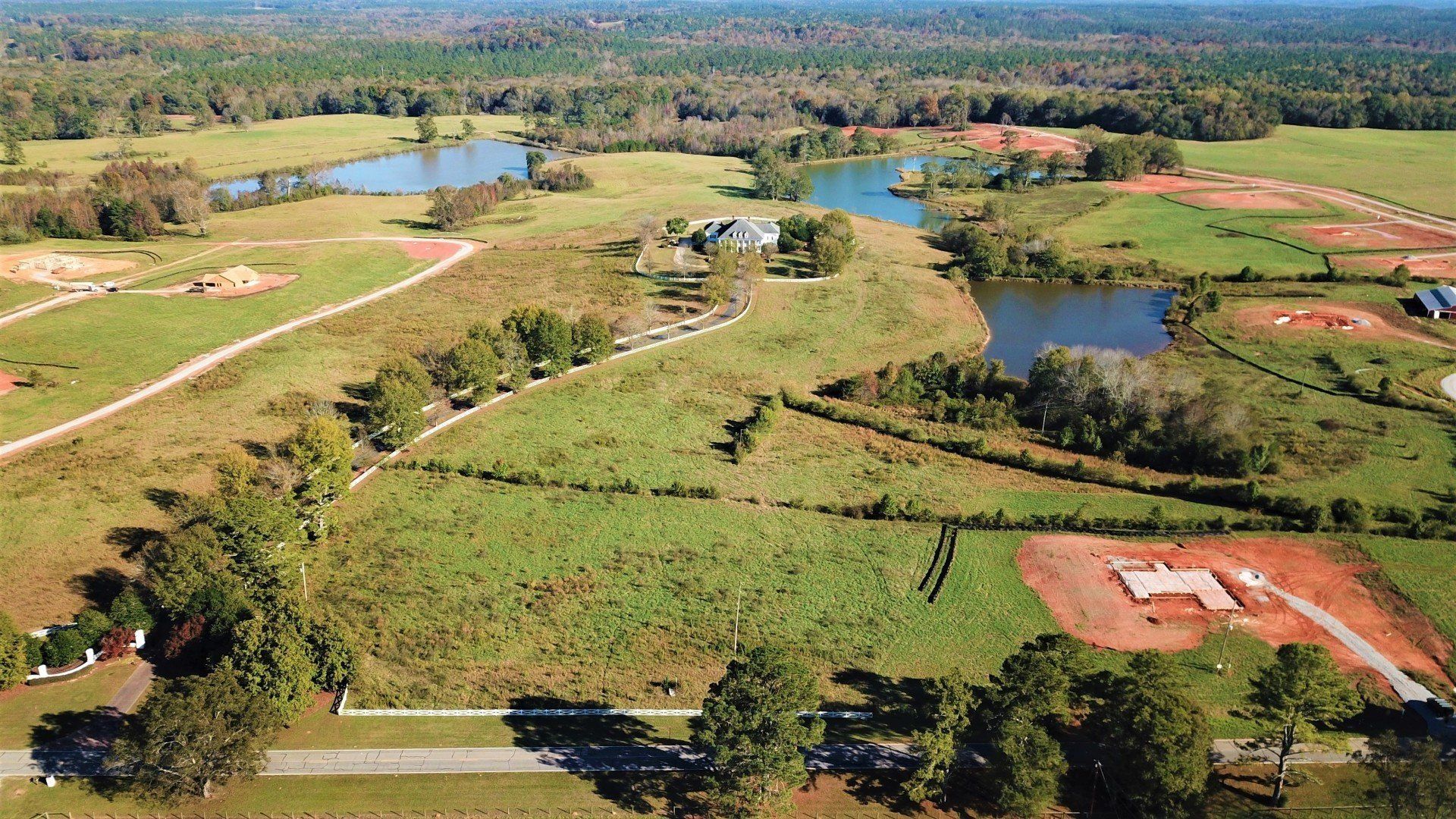 An aerial view of a lush green field with a baseball field in the middle.