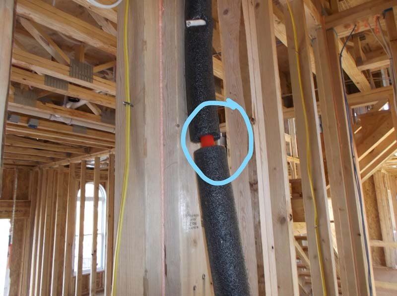 A pipe in a house under construction with a blue circle around it