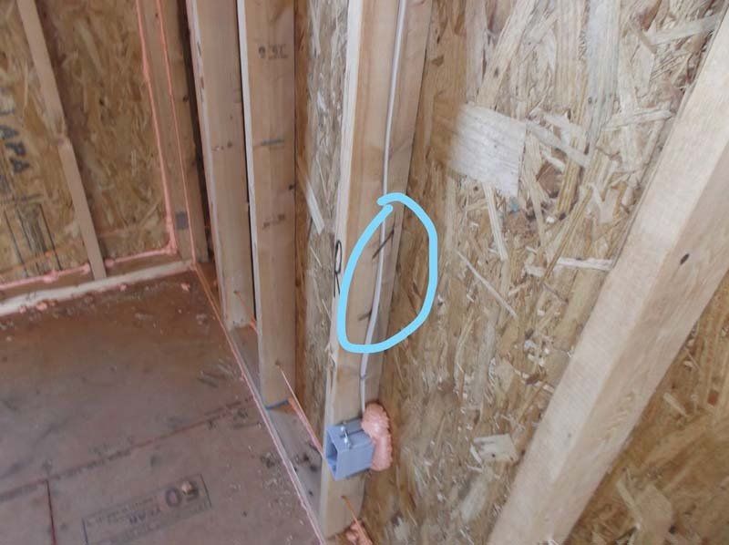 A blue circle is drawn on a wooden wall in a house under construction.
