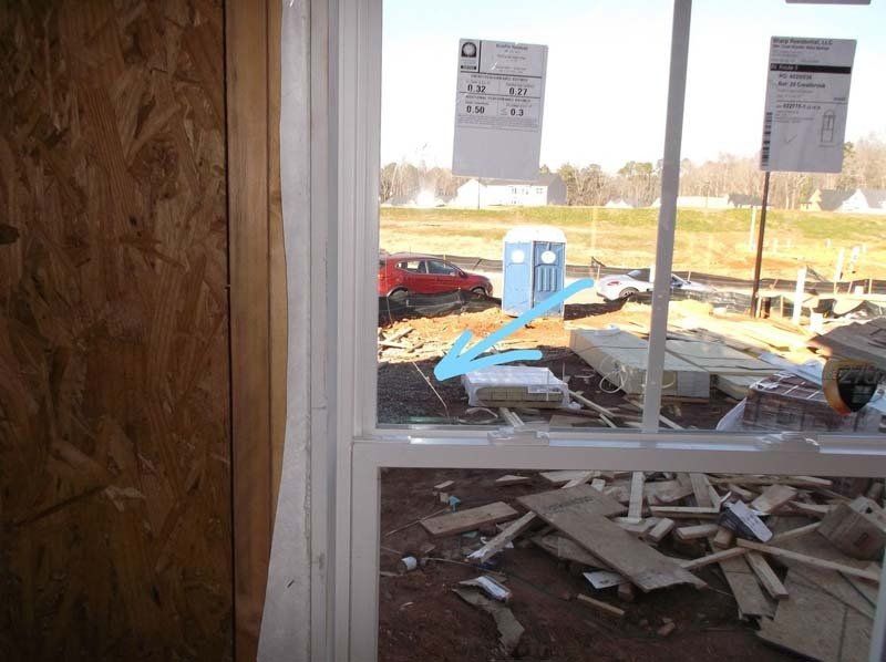 A window with a blue arrow pointing to a building under construction