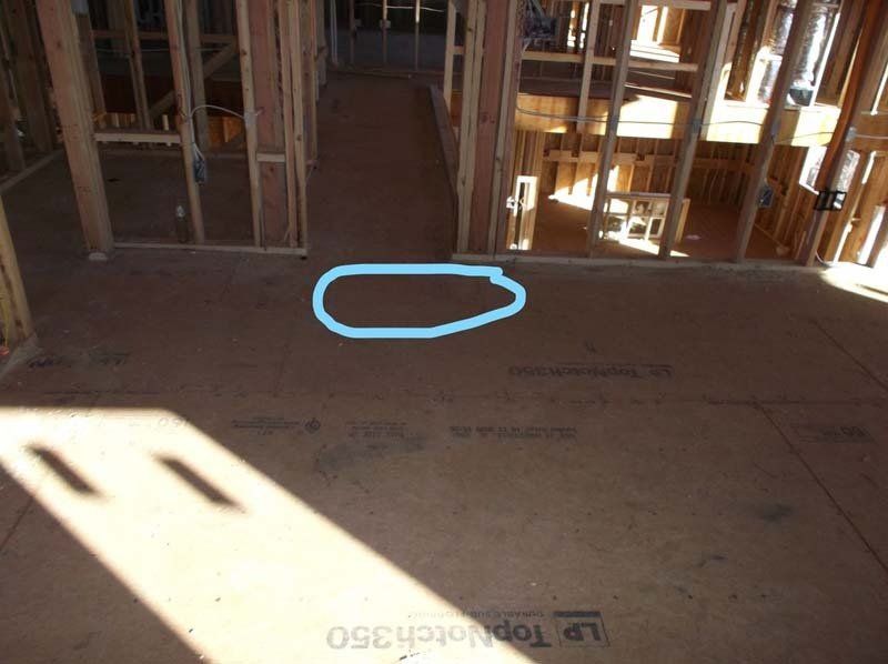 A blue circle is drawn on the floor of a house under construction