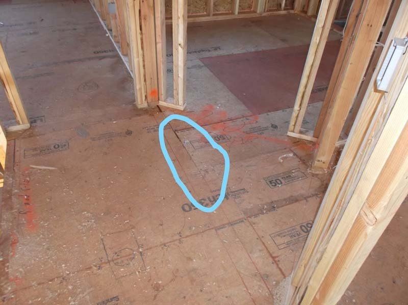 A blue circle is drawn on the floor of a building under construction.