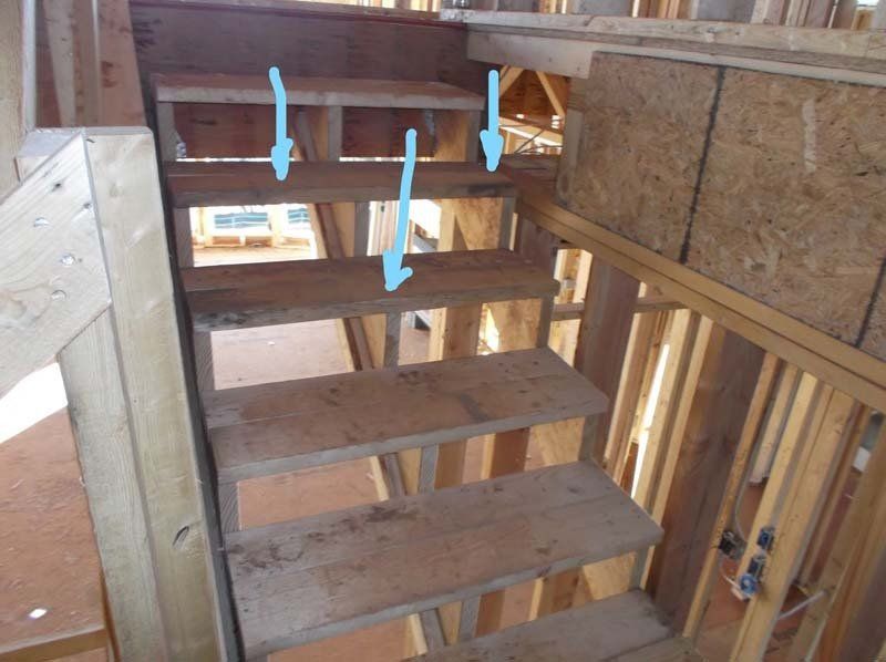 A wooden staircase with blue arrows pointing up and down