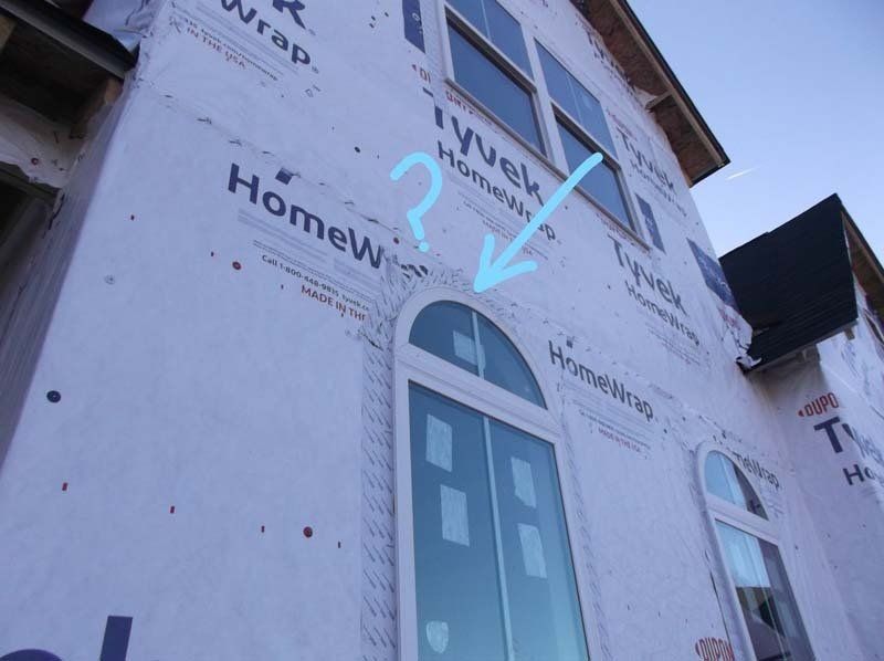 A blue arrow points to a window on the side of a building