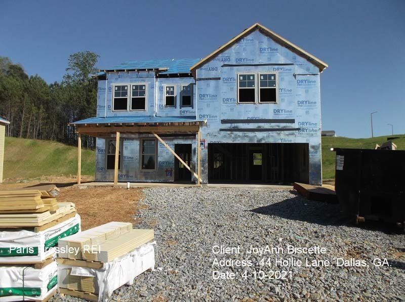 A house that is being built with a lot of wood in front of it