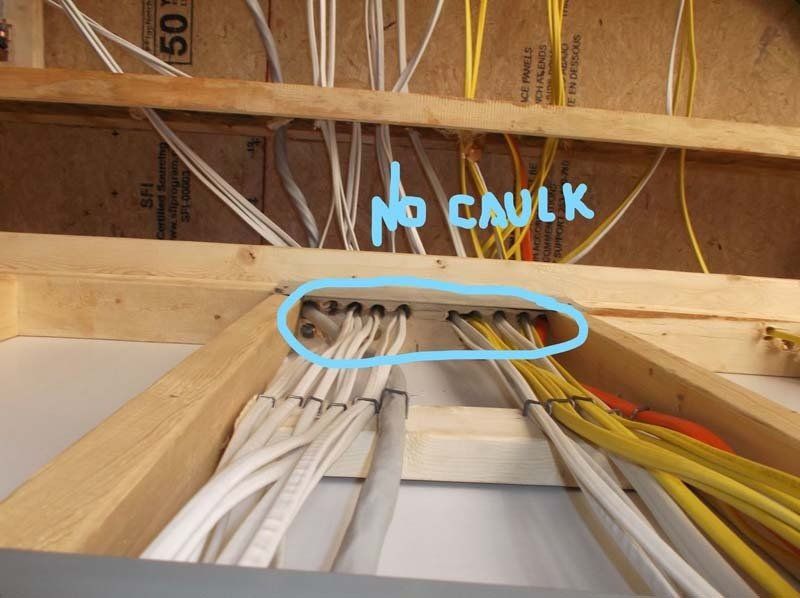 A bunch of wires in a wooden frame with the words no caulk written on it