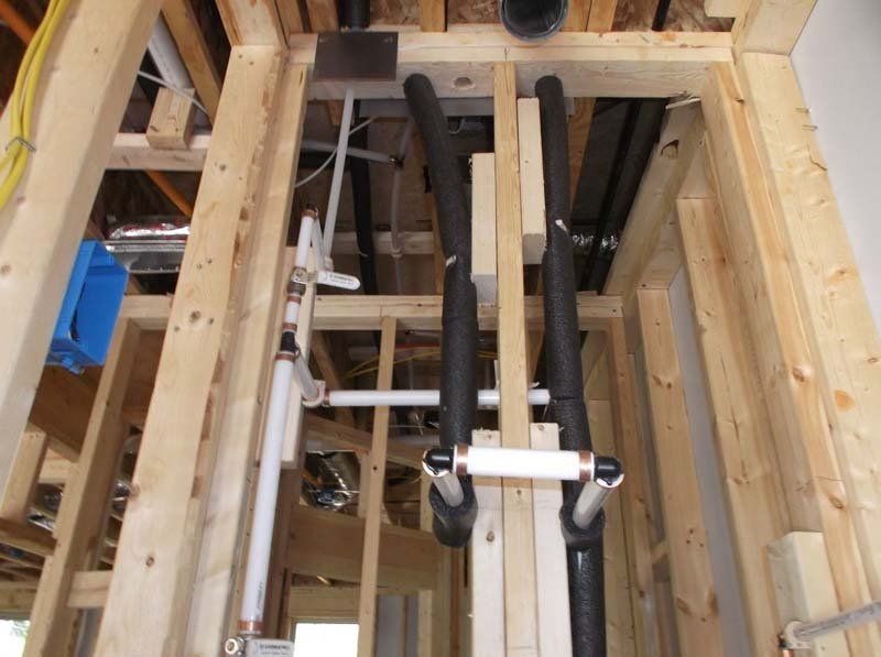 A bunch of pipes are hanging from the ceiling of a building