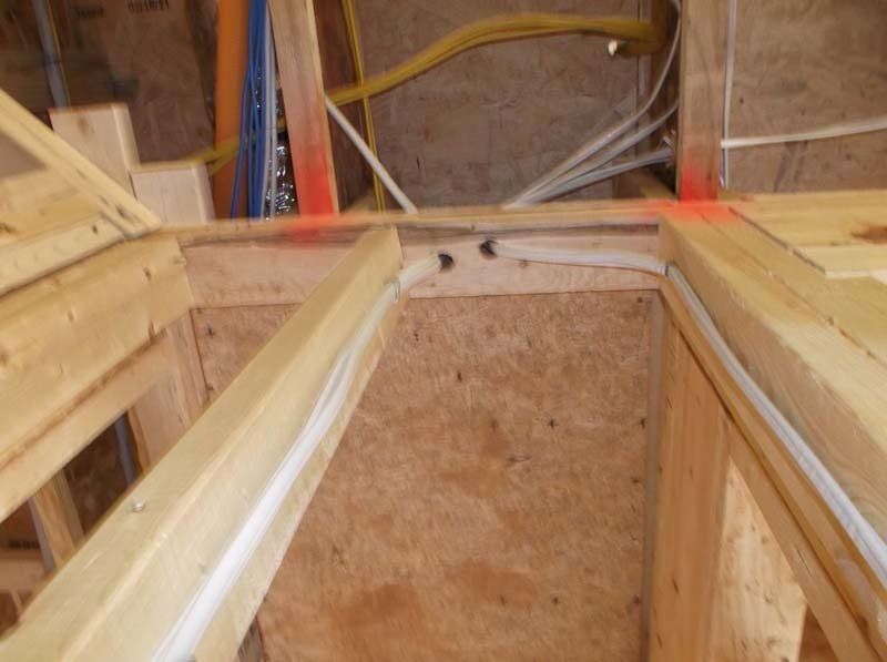 A corner of a wooden structure with a red arrow pointing to it.