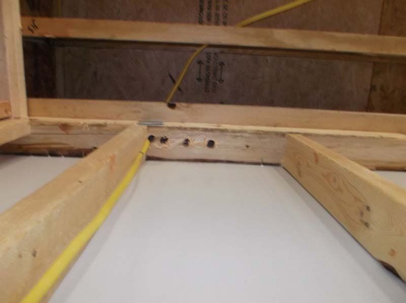A wooden frame with a yellow wire going through it