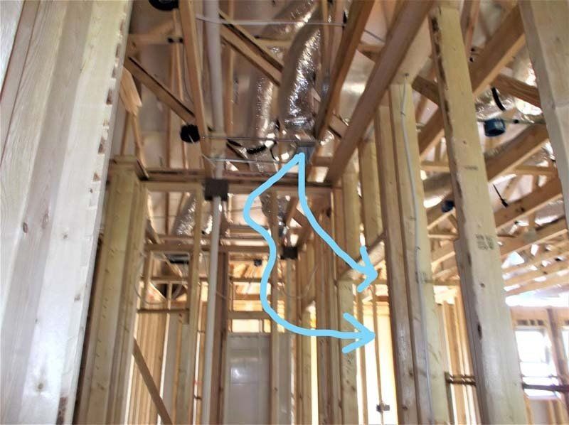 A blue arrow points to a duct in a building under construction