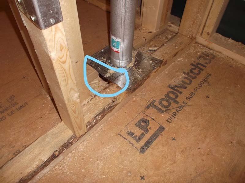 A metal pipe is sitting on top of a piece of plywood.