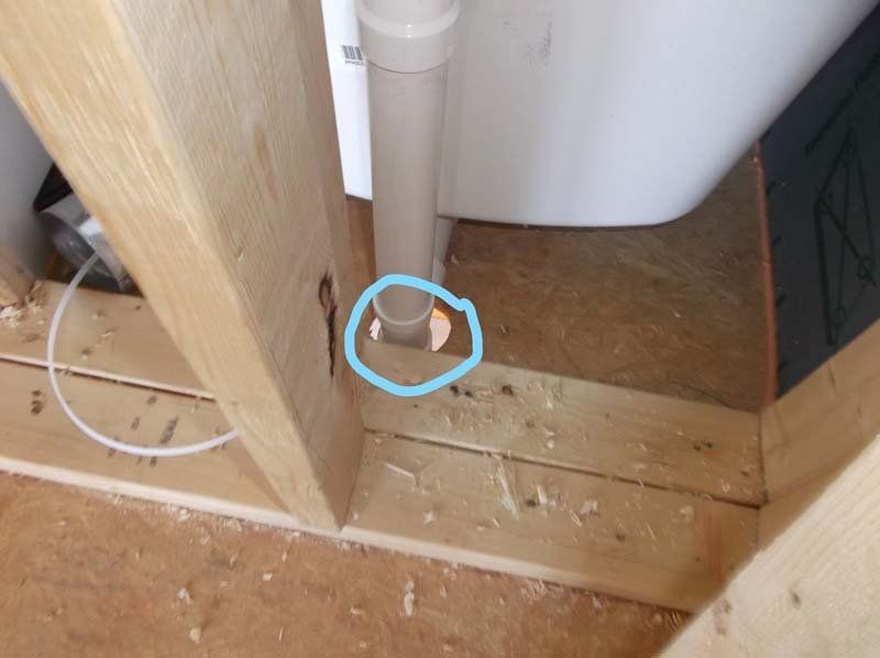 A pipe is being installed in a bathroom under a sink.
