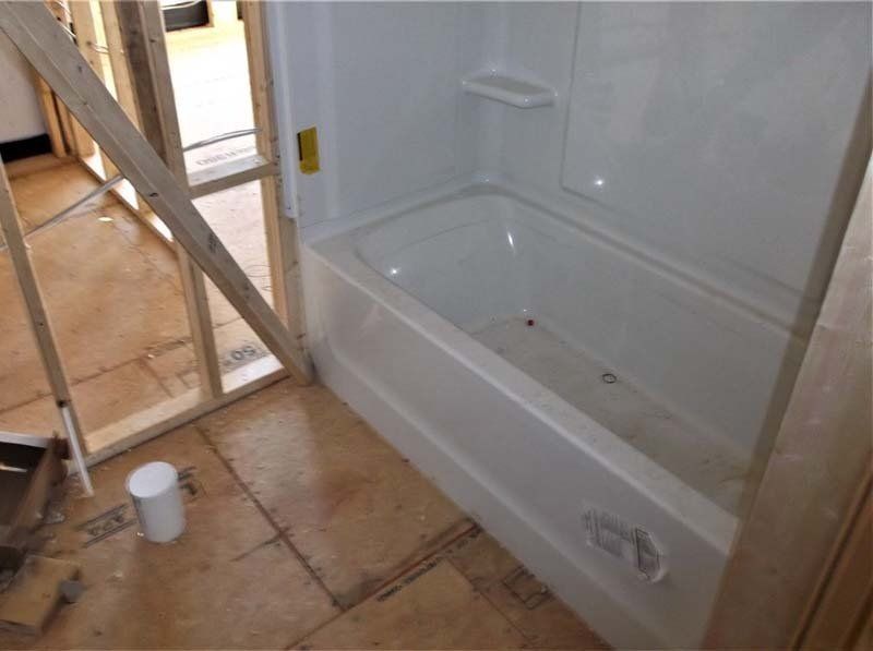 A white bathtub in a bathroom under construction