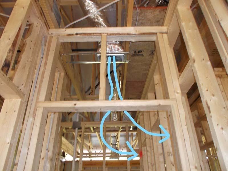 A picture of a house under construction with a blue arrow pointing to the air vent