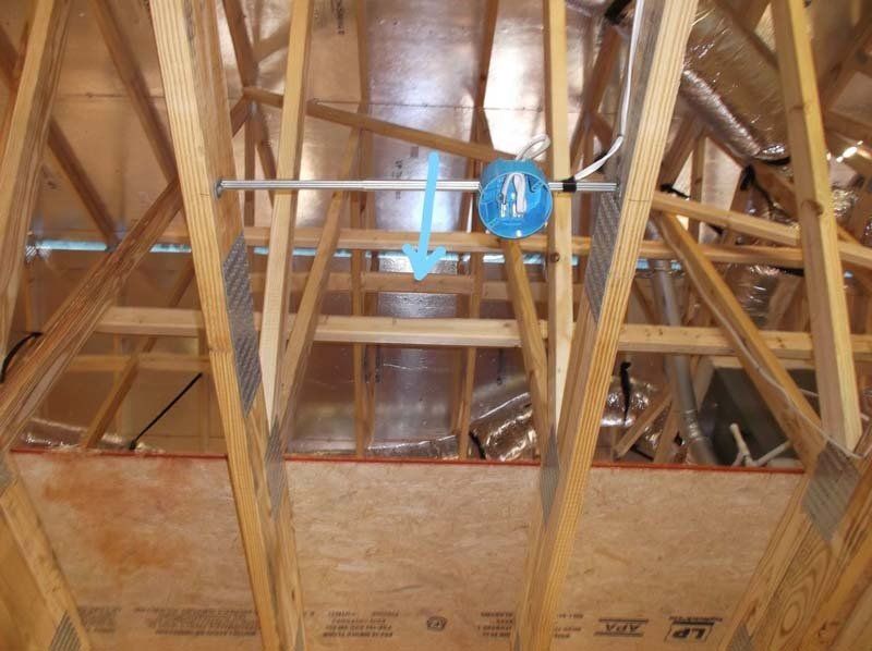 A blue arrow points to a box in the ceiling of a house