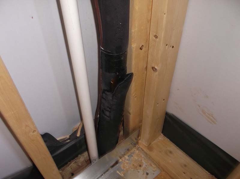 A pipe is hanging from a wooden frame in a room.