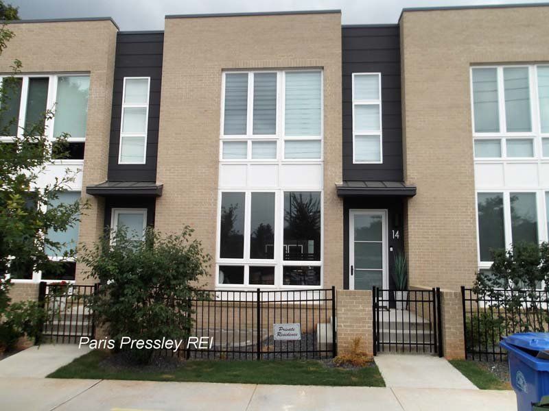 A brick building with a blue trash can in front of it