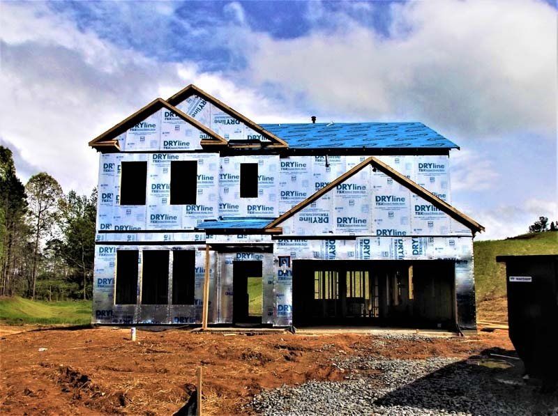 A house that is being built with a blue roof.