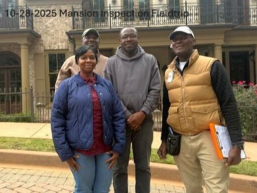 Four people standing in front of a mansion; two are holding clipboards.