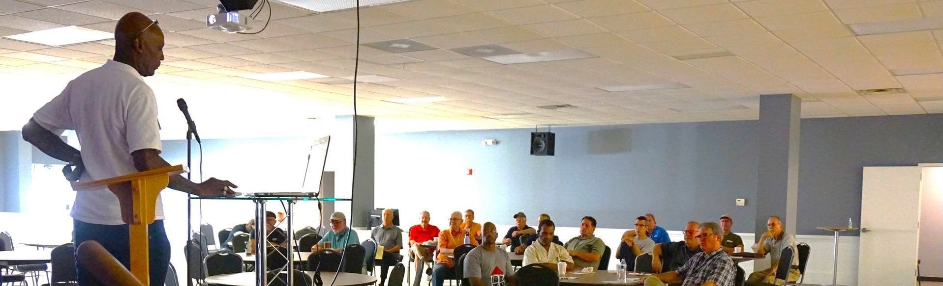 A man is standing at a podium giving a speech to a group of people.
