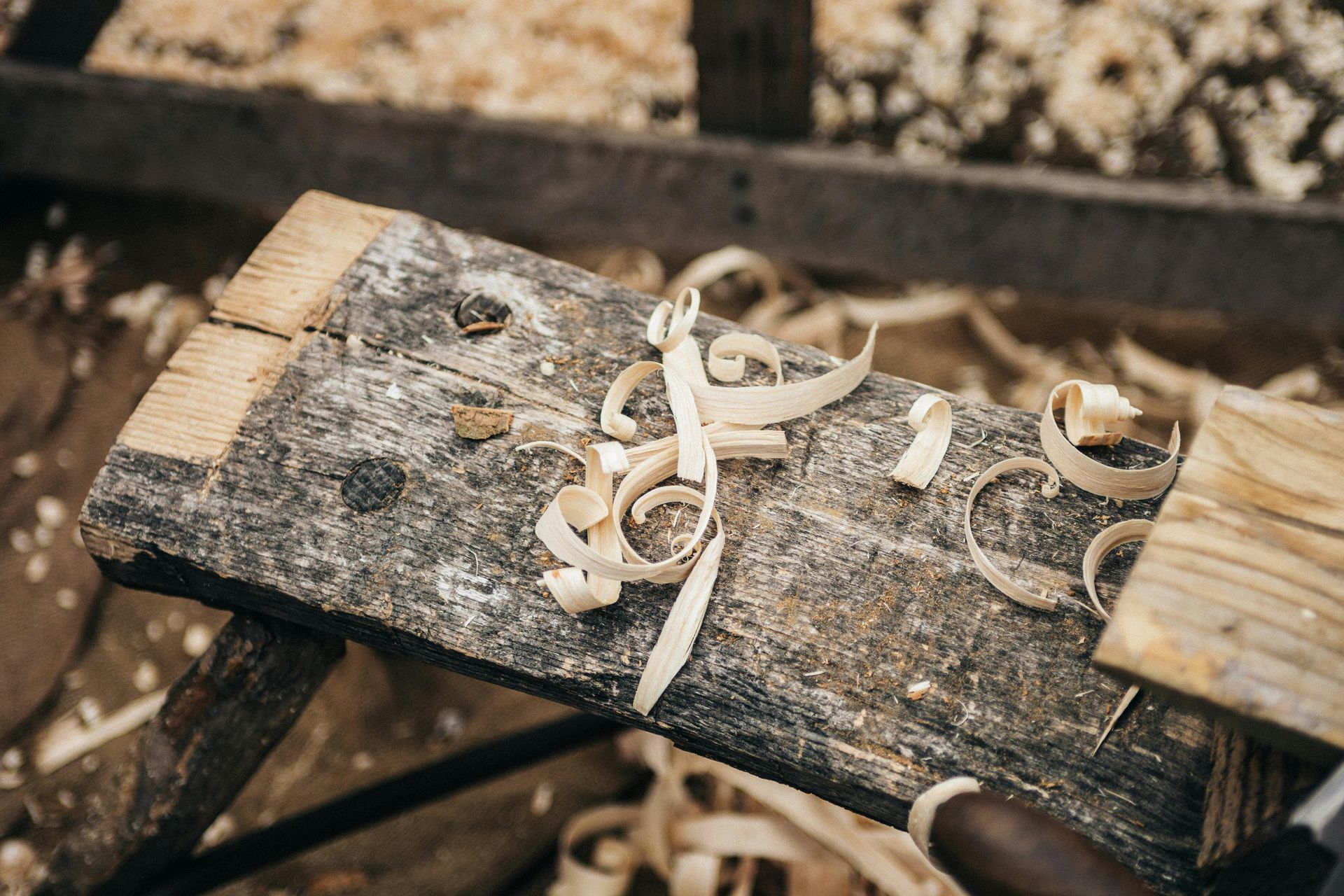 Banco da lavoro in legno con trucioli di legno arricciati; in una falegnameria.