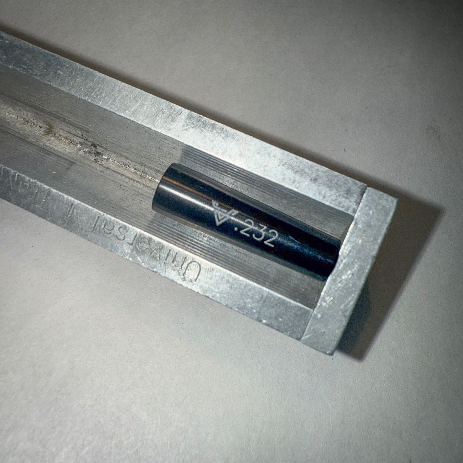 A machine is cutting a piece of metal with sparks coming out of it.