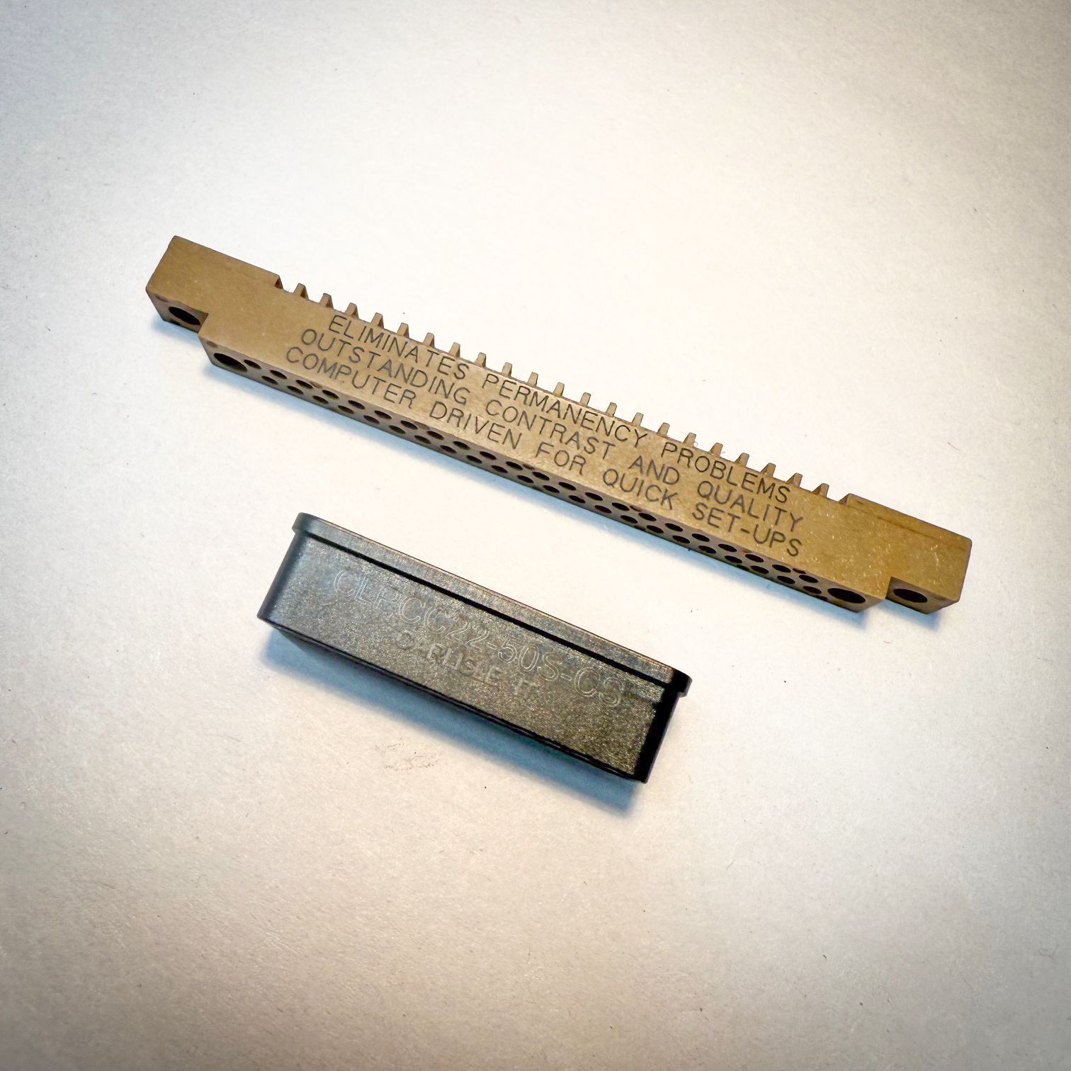 A machine is cutting a piece of metal with the letter s on it.