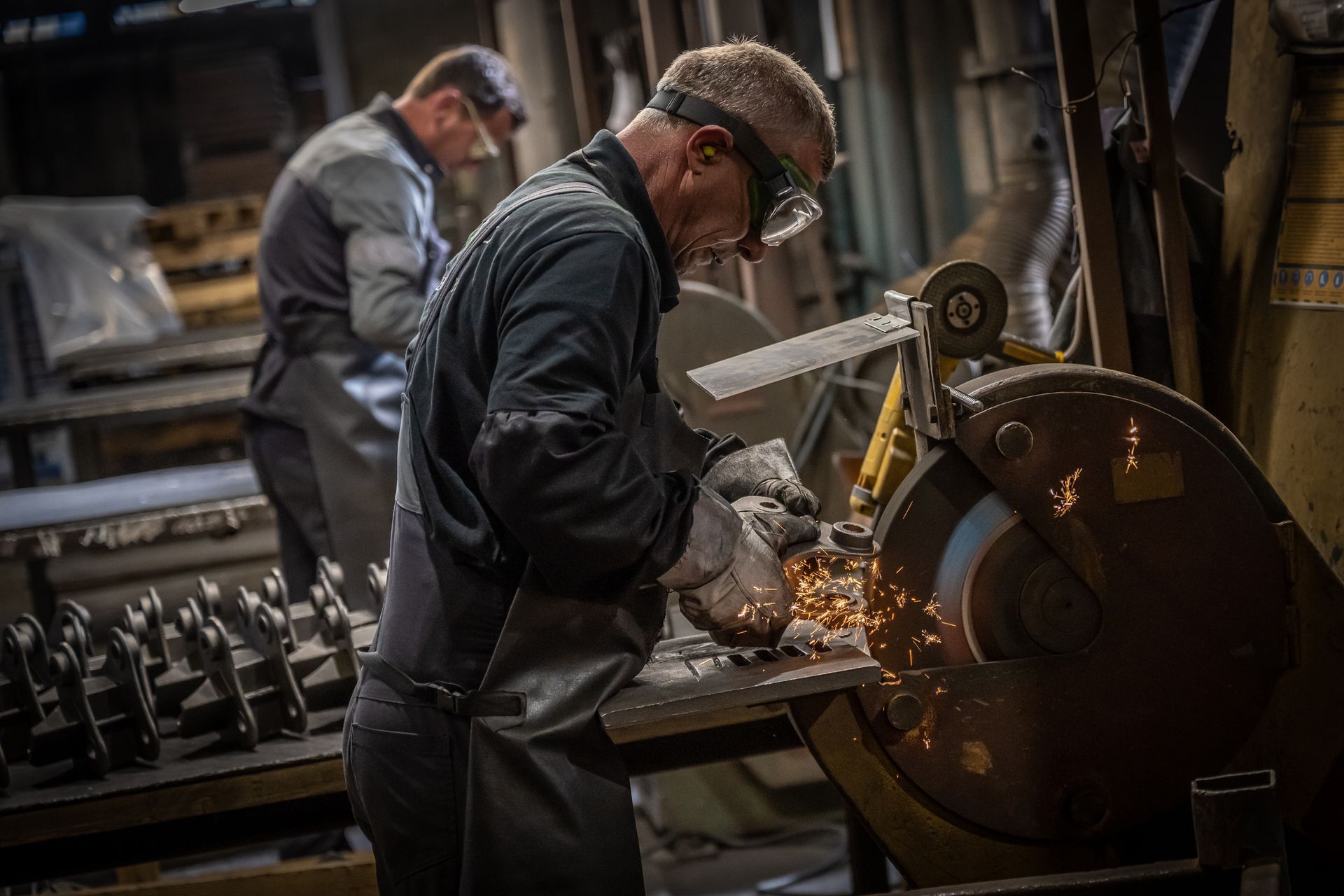 A person is painting a piece of metal in a room.
