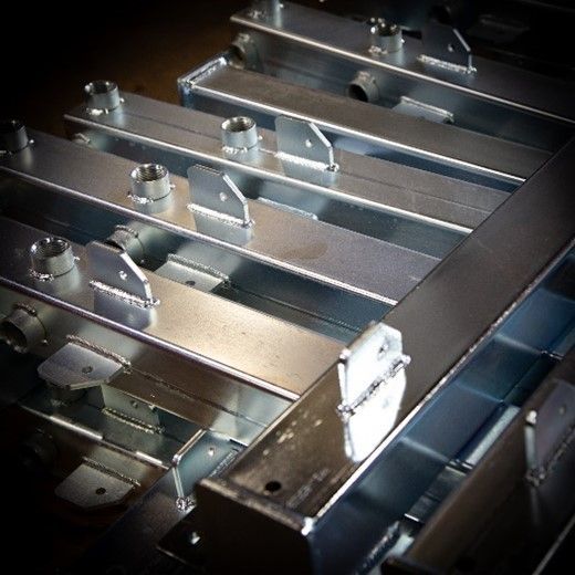 There are many different types of aluminum profiles on a shelf.