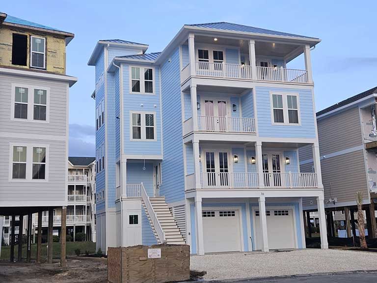 A blue house with a lot of windows and balconies