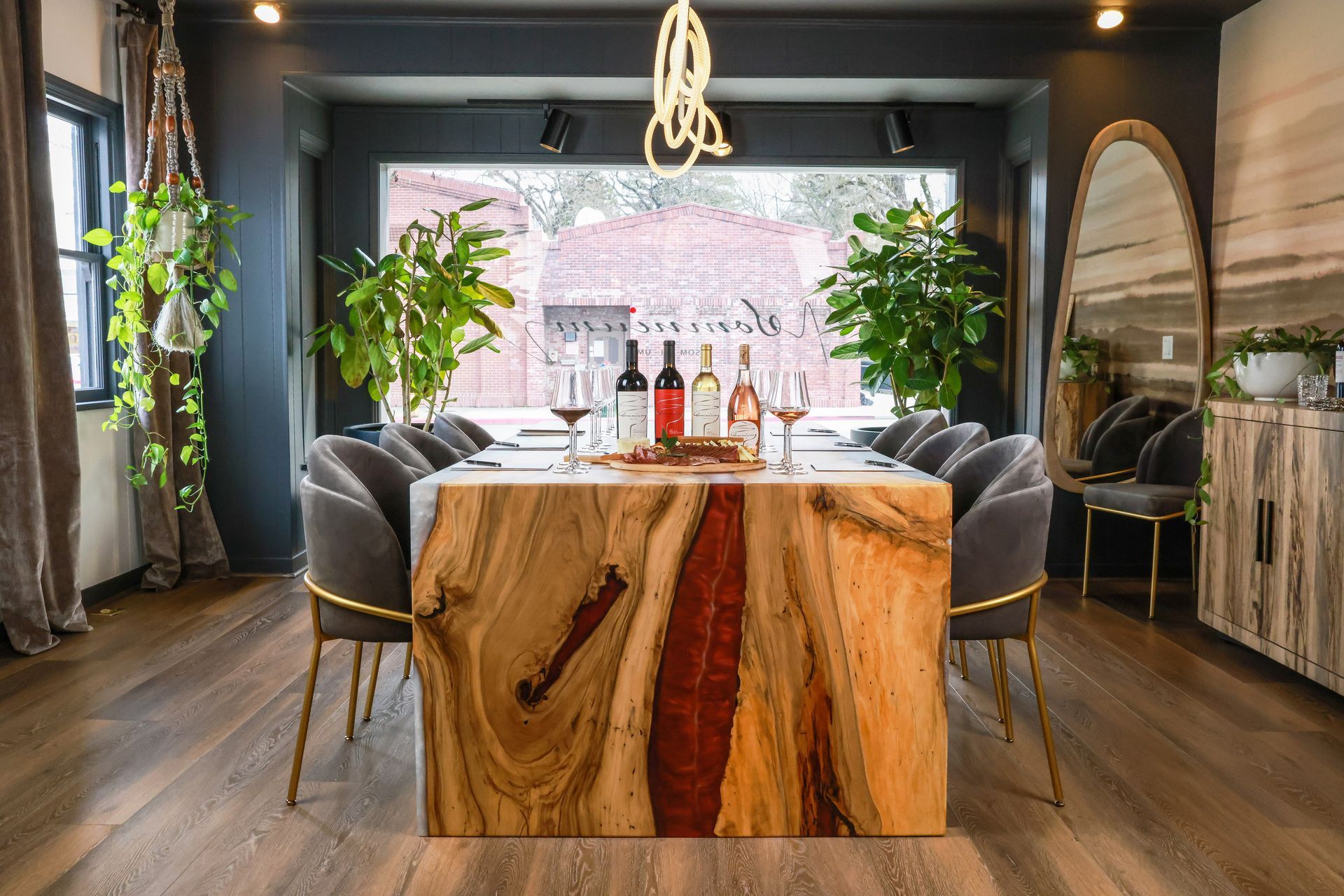 Dining room with a wooden table, chairs, and bottles of wine.