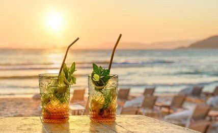 Two mojitos are sitting on a table on the beach at sunset — Bali Hi Motel In Tuncurry, NSW
